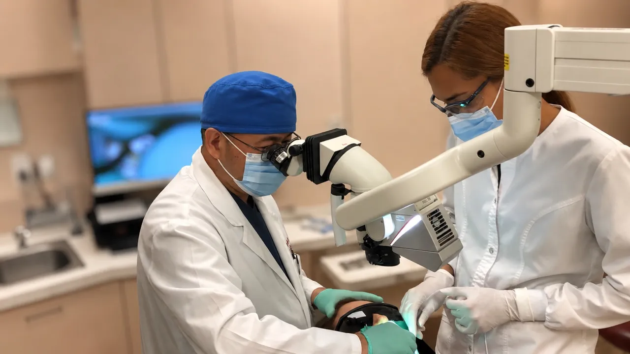 Dr. Minh Nguyen providing dental treatment with a clinical team member, showing careful patient care